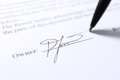 Photo of Pen leaving signature on contract, closeup view