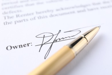 Photo of Signature and pen on paperwork, closeup view