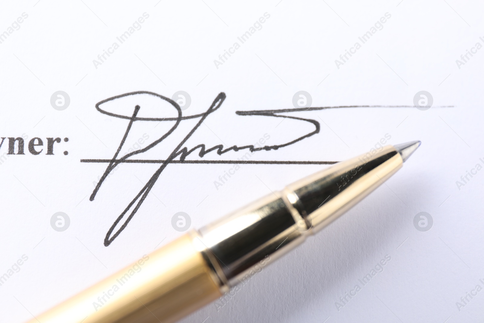 Photo of Signature and pen on paperwork, closeup view