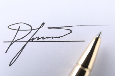 Photo of Pen and signature on white paper, closeup