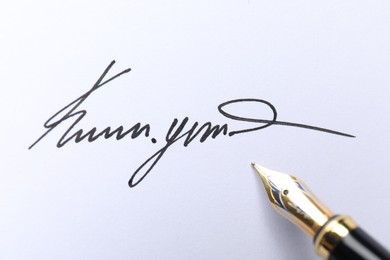 Photo of Fountain pen and signature on white paper, closeup