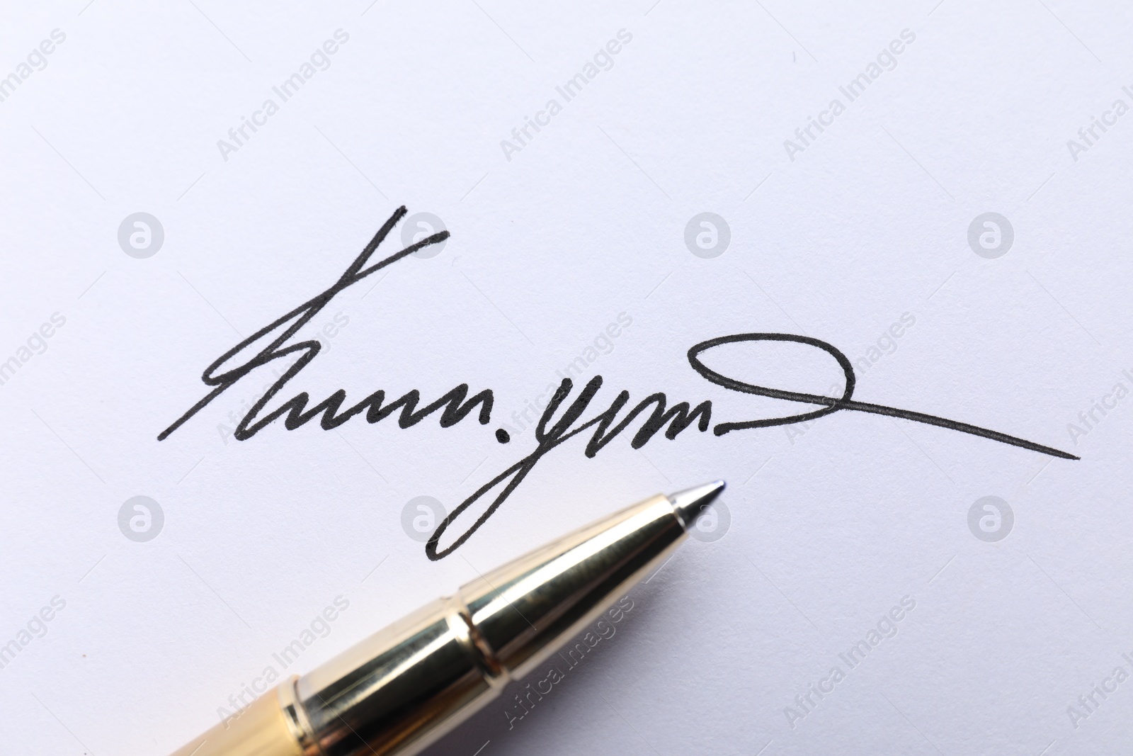 Photo of Pen and signature on white paper, closeup