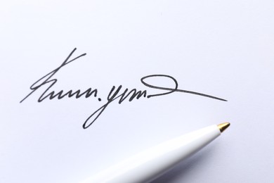 Photo of Pen and signature on white paper, closeup