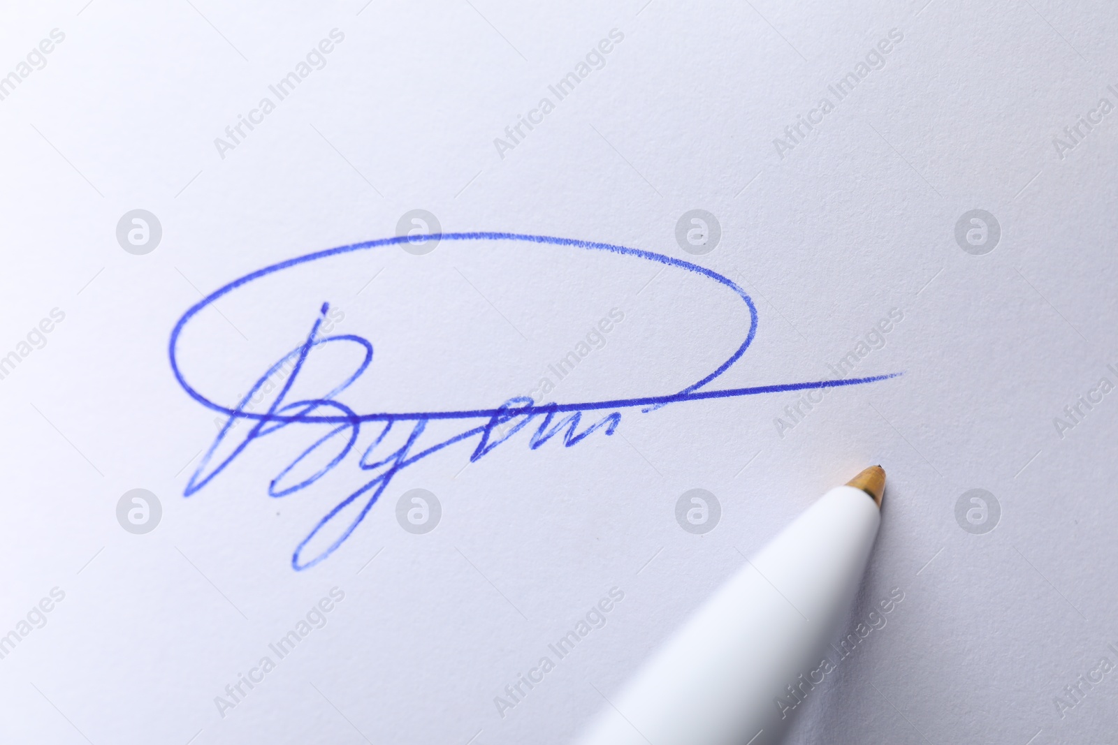 Photo of Pen and signature on white paper, closeup