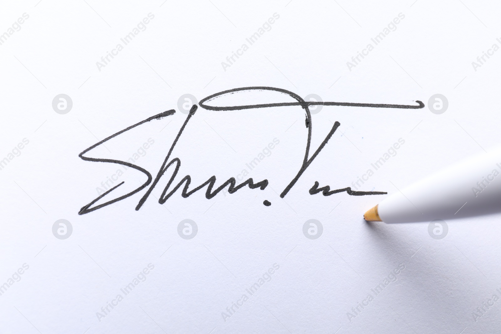 Photo of Pen and signature on white paper, closeup