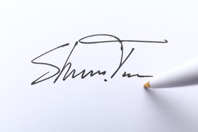 Pen and signature on white paper, closeup