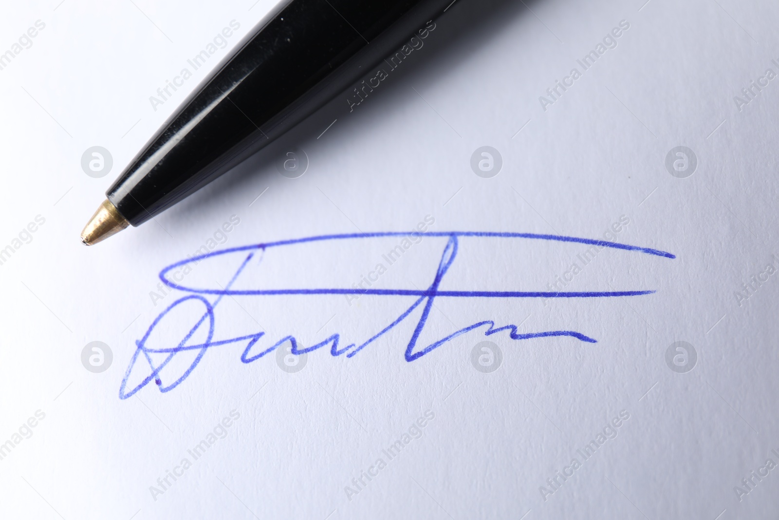 Photo of Pen and signature on white paper, closeup