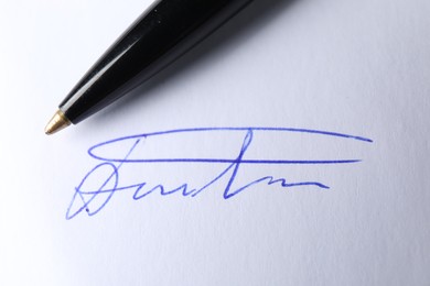 Photo of Pen and signature on white paper, closeup