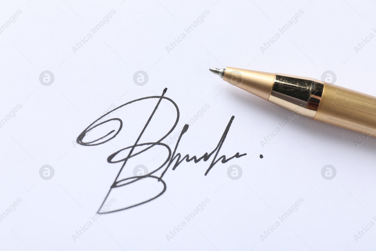 Photo of Pen and signature on white paper, closeup