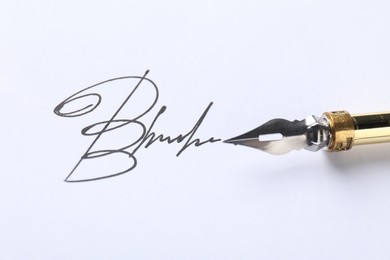 Photo of Fountain pen and signature on white paper, closeup