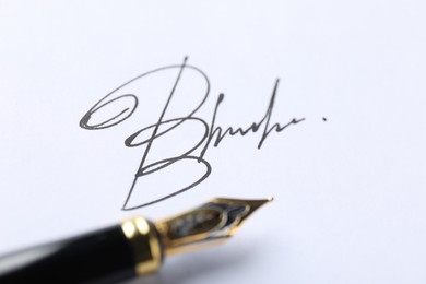 Photo of Fountain pen and signature on white paper, closeup