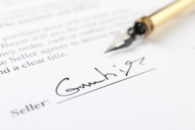 Photo of Signature and fountain pen on paperwork, closeup view