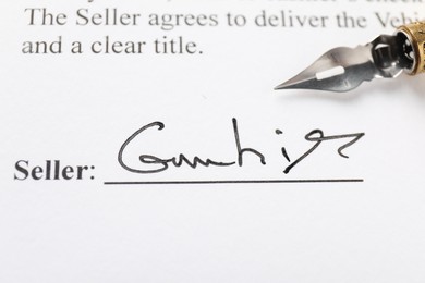 Photo of Signature and fountain pen on paperwork, closeup view