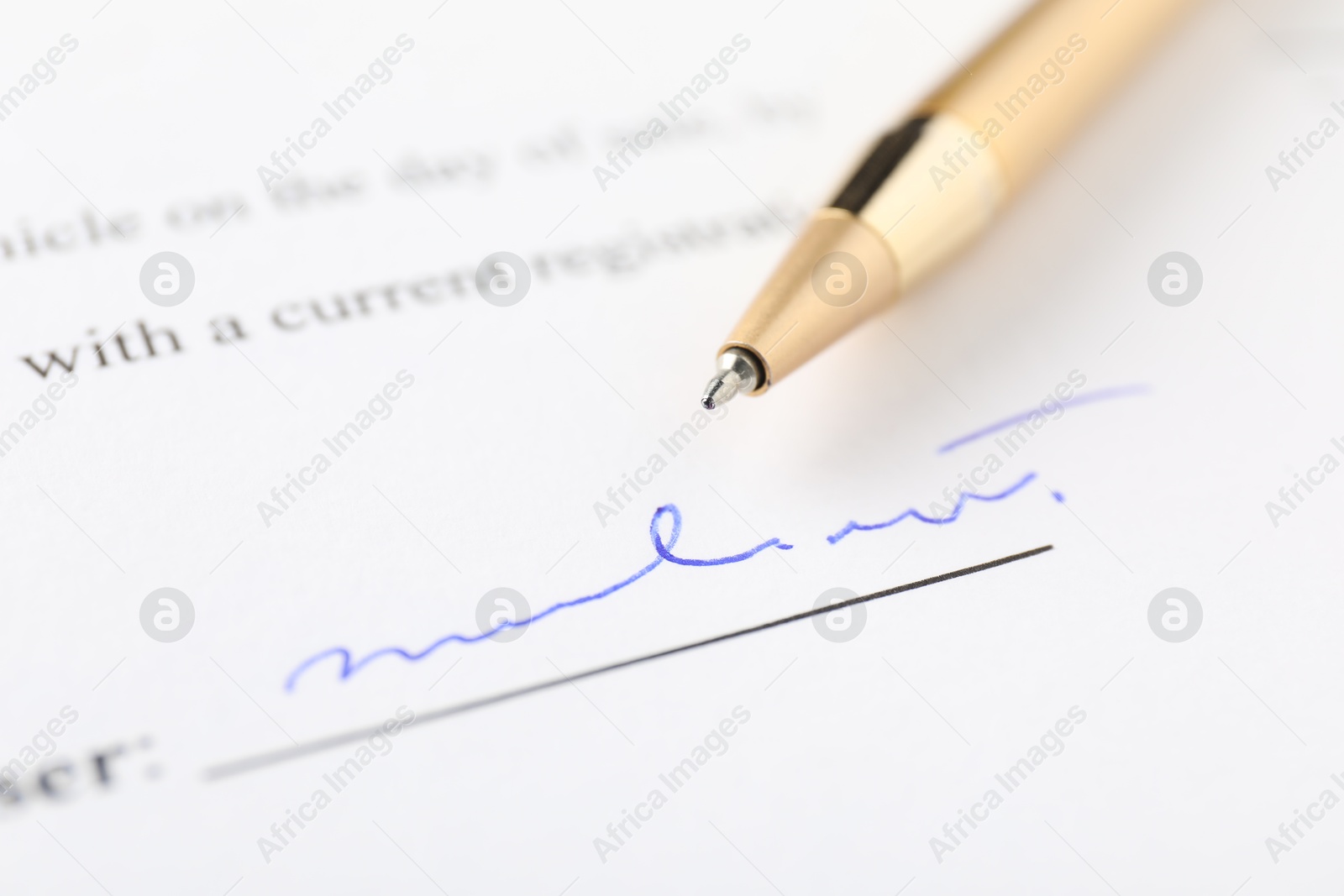 Photo of Signature and pen on paperwork, closeup view