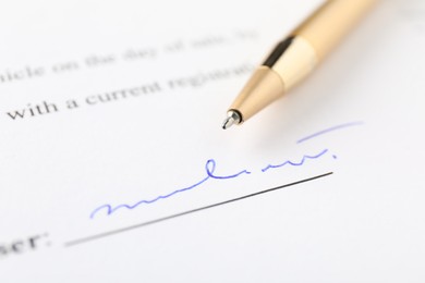 Photo of Signature and pen on paperwork, closeup view