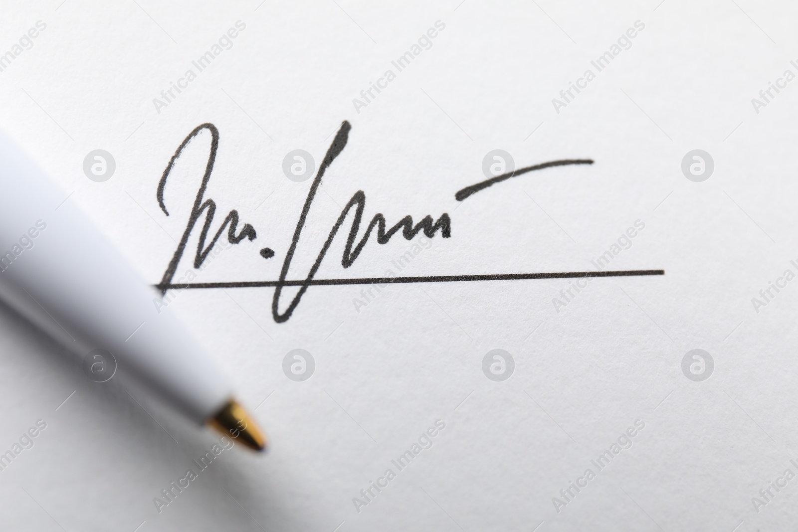 Photo of Signature and pen on paperwork, closeup view