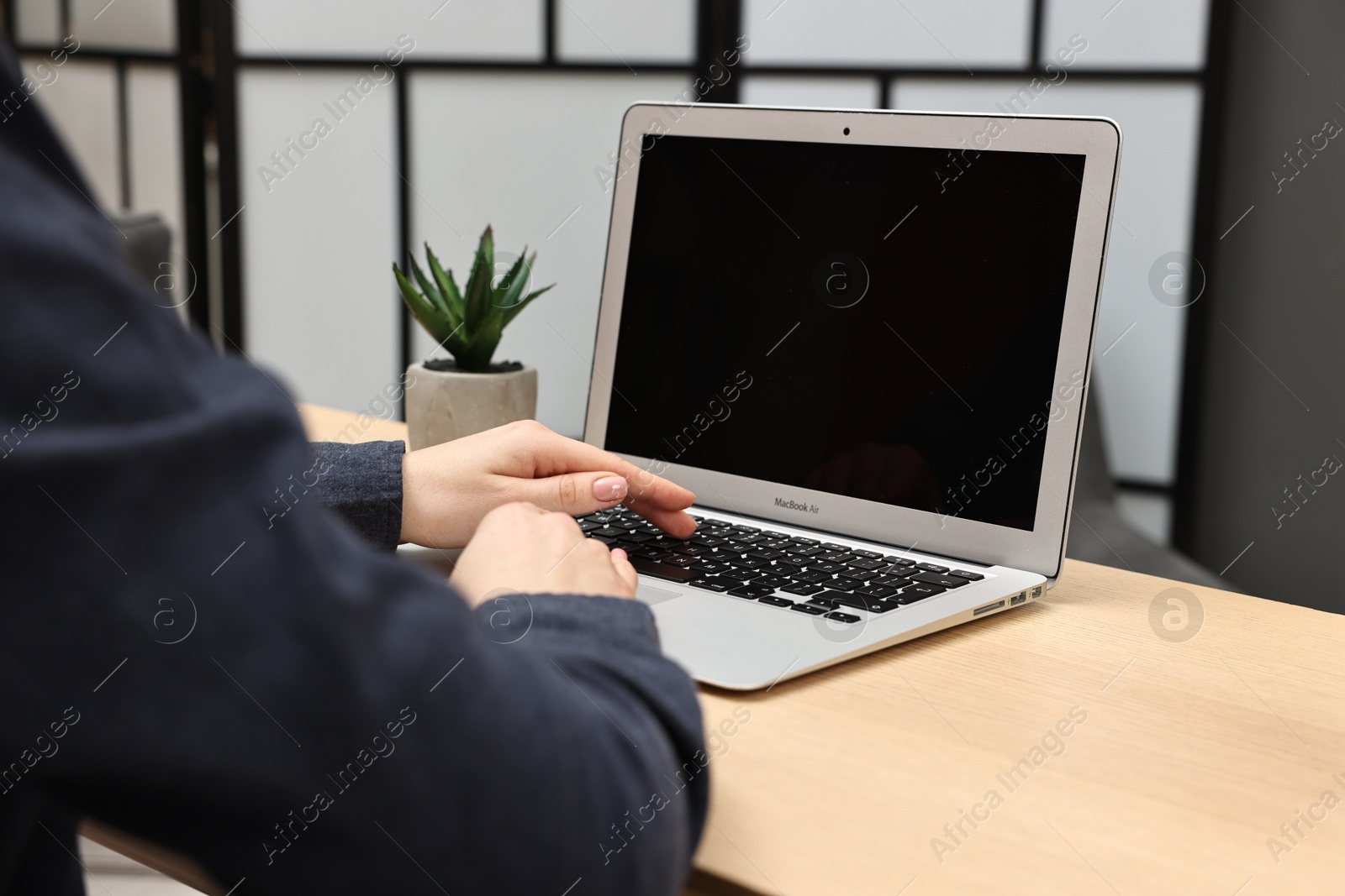 Photo of Woman working on computer at desk indoors, closeup