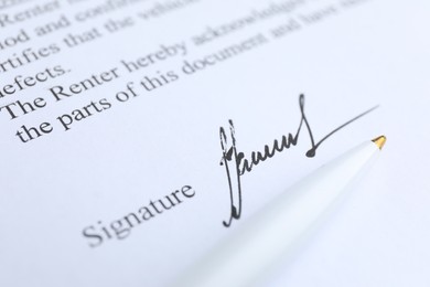 Photo of Ballpoint pen and signature on contract, closeup