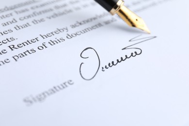 Photo of Fountain pen leaving signature on contract, closeup