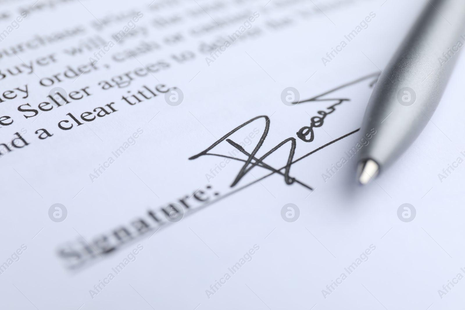 Photo of Ballpoint pen and signature on contract, closeup