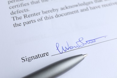 Photo of Ballpoint pen and signature on contract, closeup