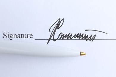 Photo of Ballpoint pen and signature on contract, top view