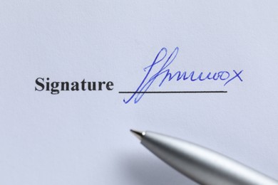 Photo of Ballpoint pen and signature on contract, top view