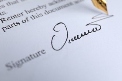 Photo of Fountain pen leaving signature on contract, closeup