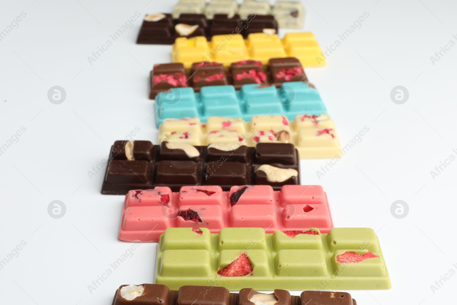 Photo of Different tasty chocolate bars on white background, closeup