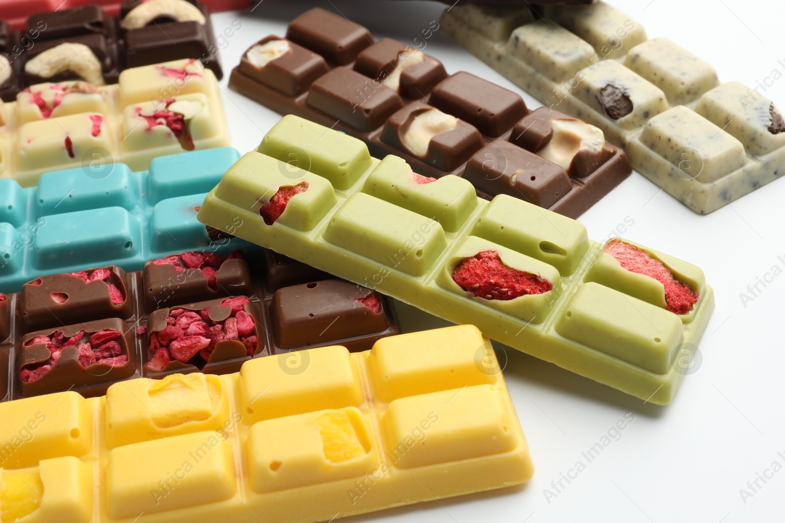 Photo of Different tasty chocolate bars on white background, closeup