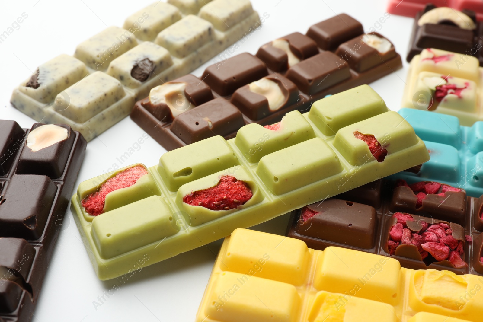 Photo of Different tasty chocolate bars on white background, closeup