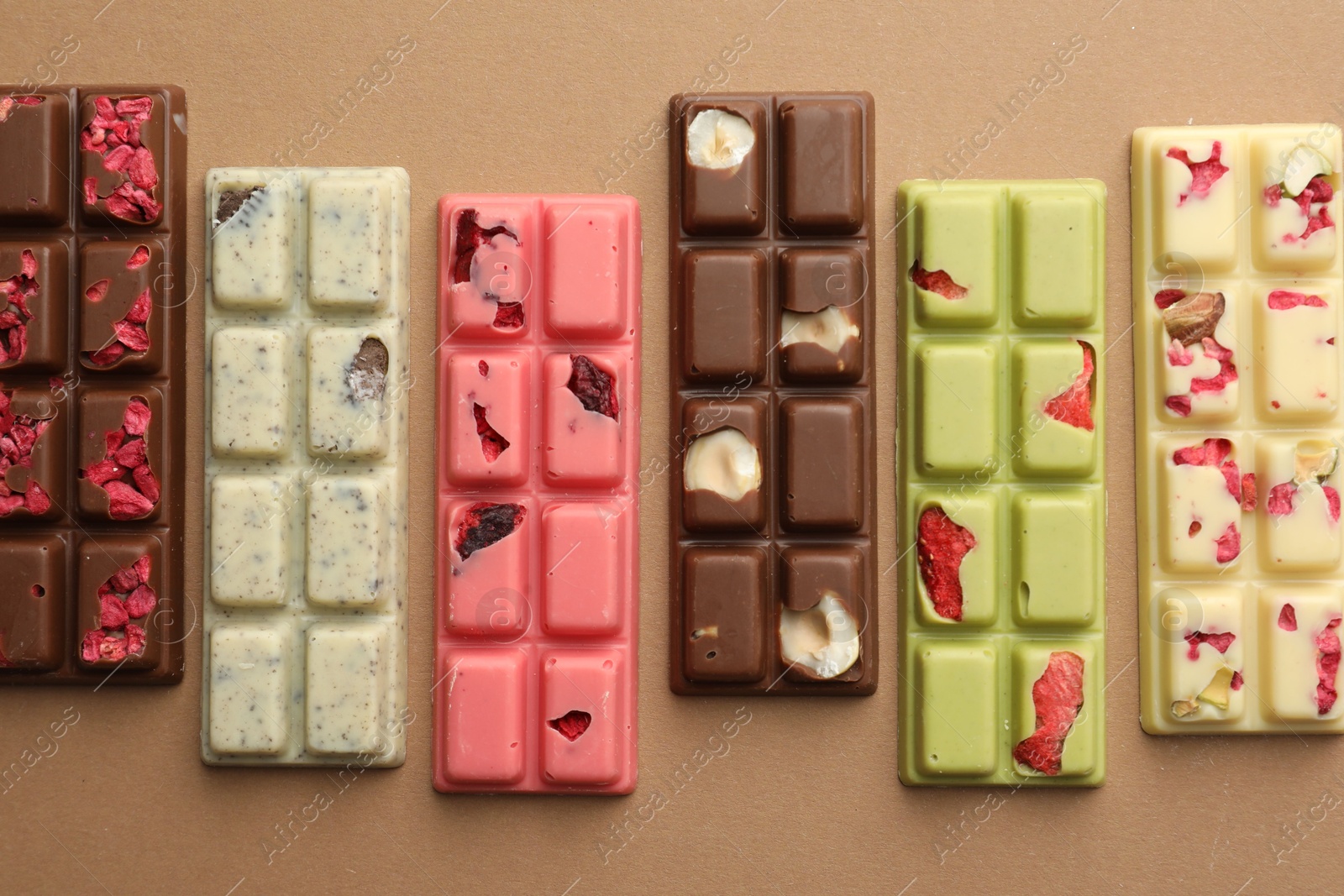 Photo of Different tasty chocolate bars on beige background, flat lay