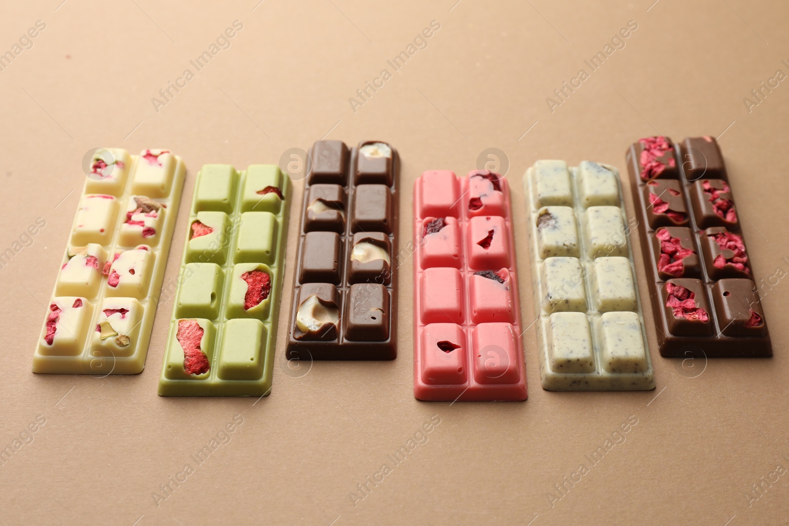 Photo of Different tasty chocolate bars on beige background