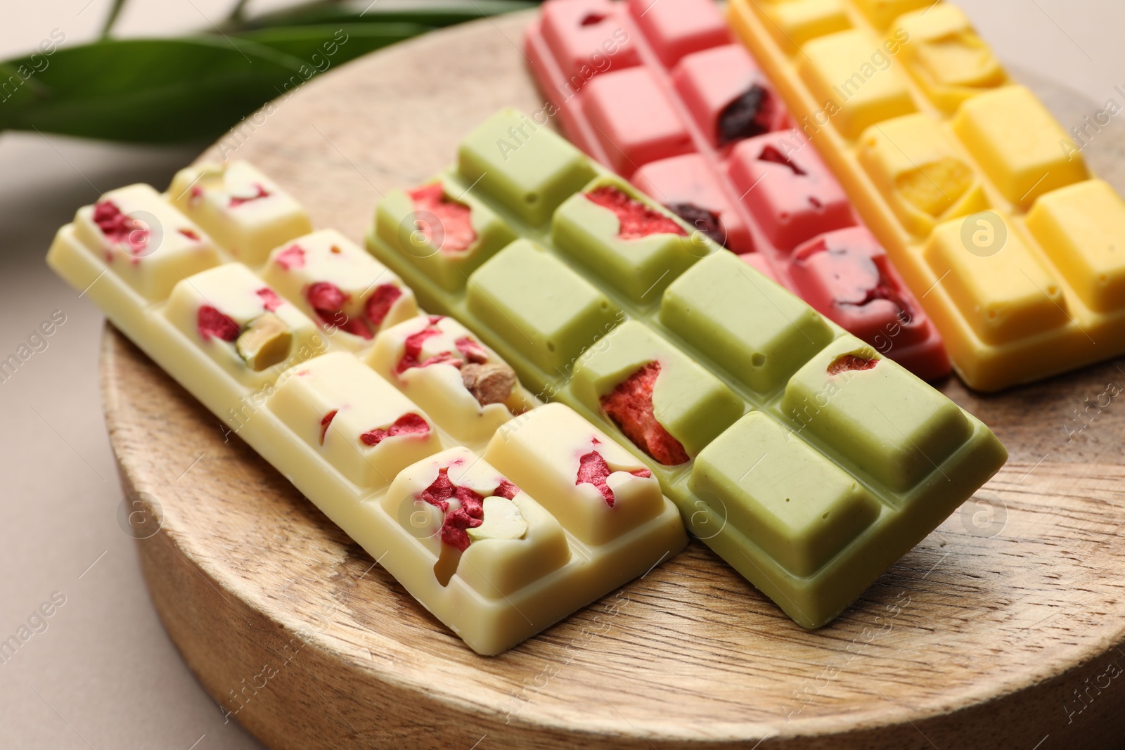 Photo of Different tasty chocolate bars on beige background, closeup