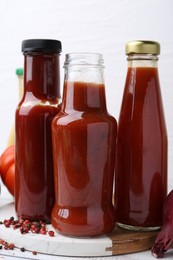 Photo of Tasty sauces in glass bottles and fresh products on wooden table, closeup