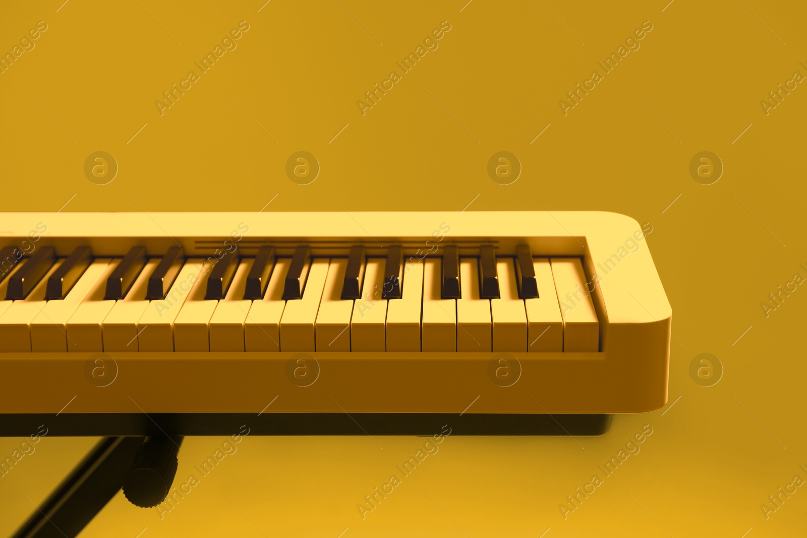 Image of Synthesizer, closeup. Toned in yellow color. Electronic musical instrument