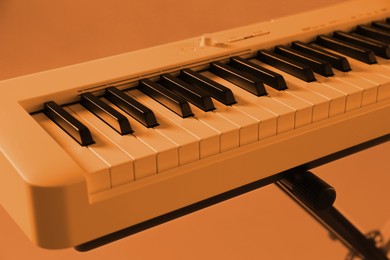 Synthesizer, closeup. Toned in orange color. Electronic musical instrument