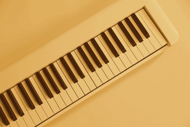 Image of Synthesizer, top view. Toned in yellow color. Electronic musical instrument