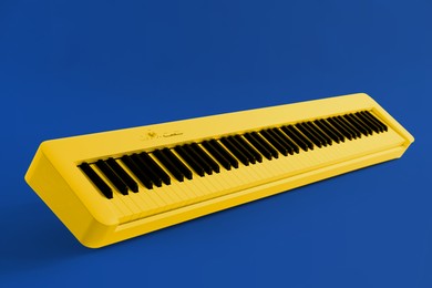 Image of Yellow synthesizer on blue background. Electronic musical instrument