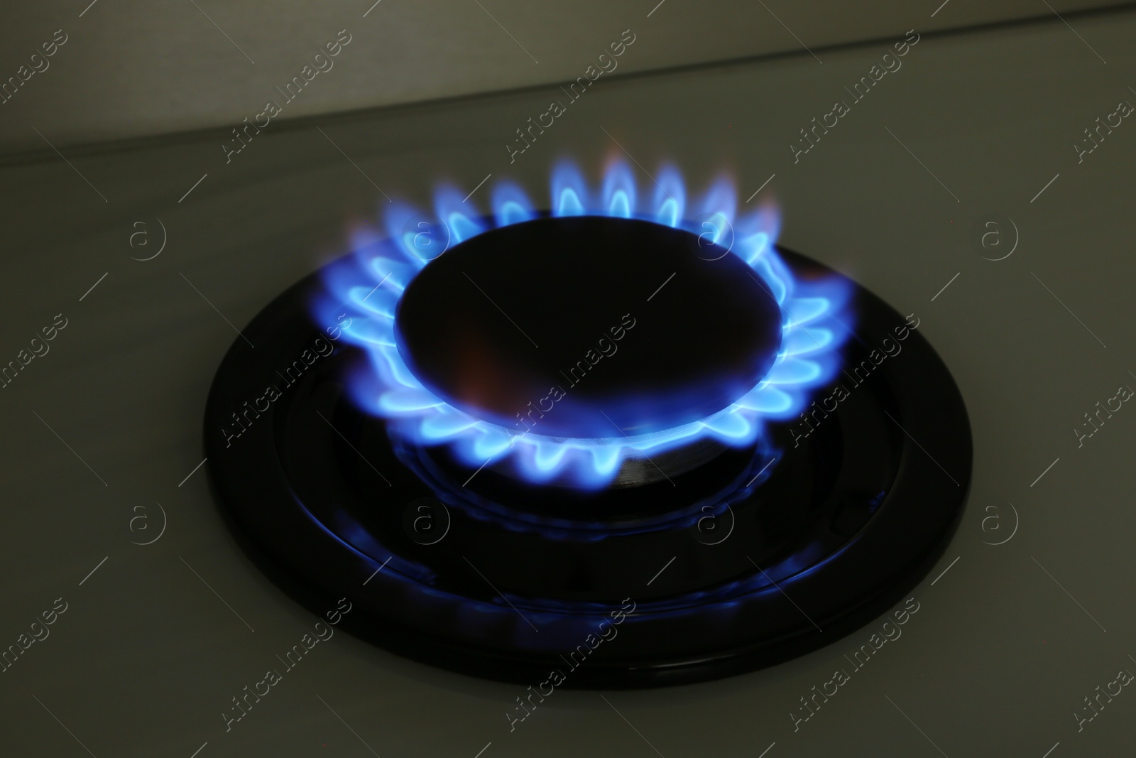 Photo of Gas burner of modern stove with burning blue flame