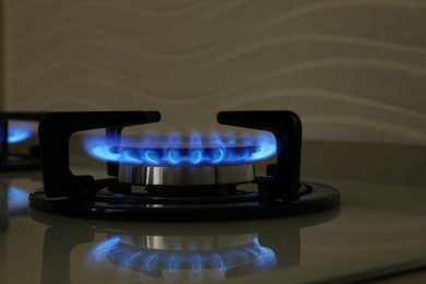 Photo of Gas burner of modern stove with burning blue flame