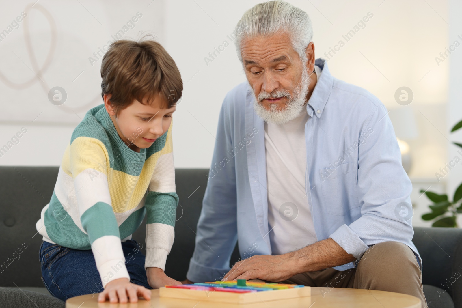 Photo of Grandpa and his grandson playing with math game Times table tray at home