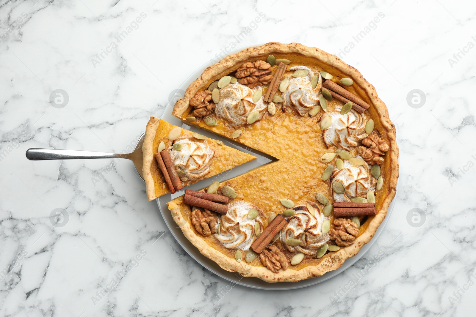 Photo of Tasty homemade pumpkin pie with server on white marble table, top view