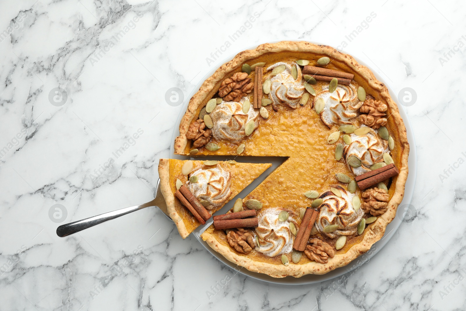 Photo of Tasty homemade pumpkin pie with server on white marble table, top view