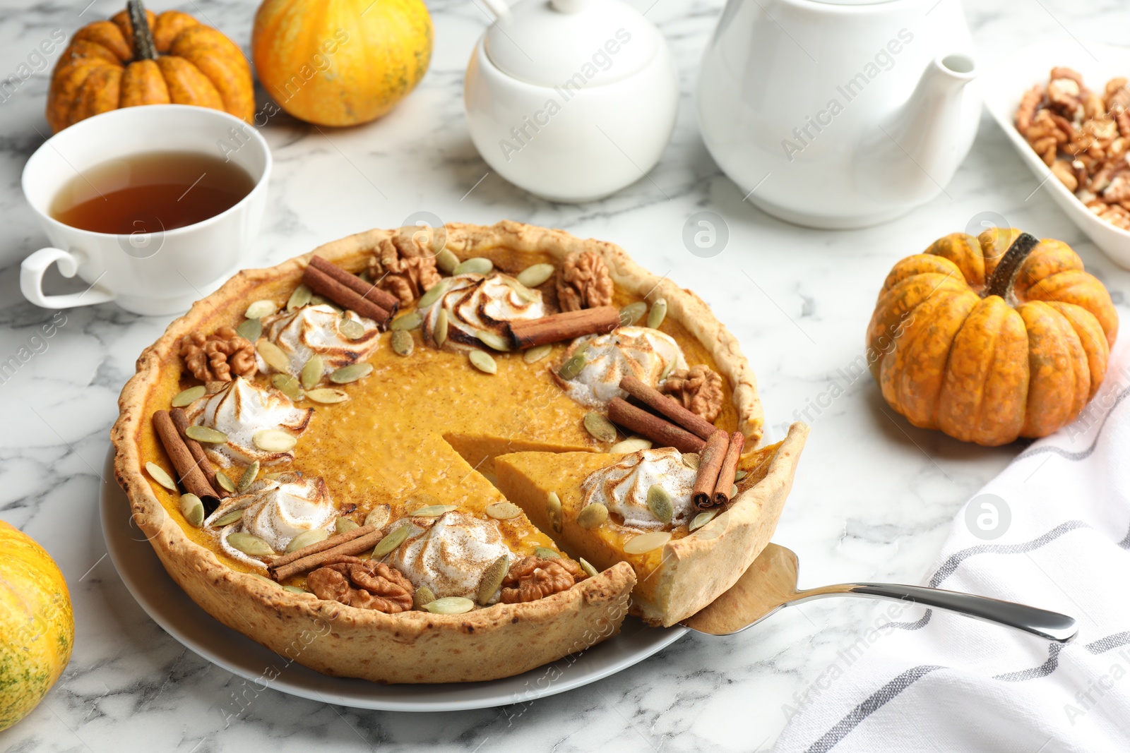 Photo of Tasty homemade pumpkin pie served on white marble table