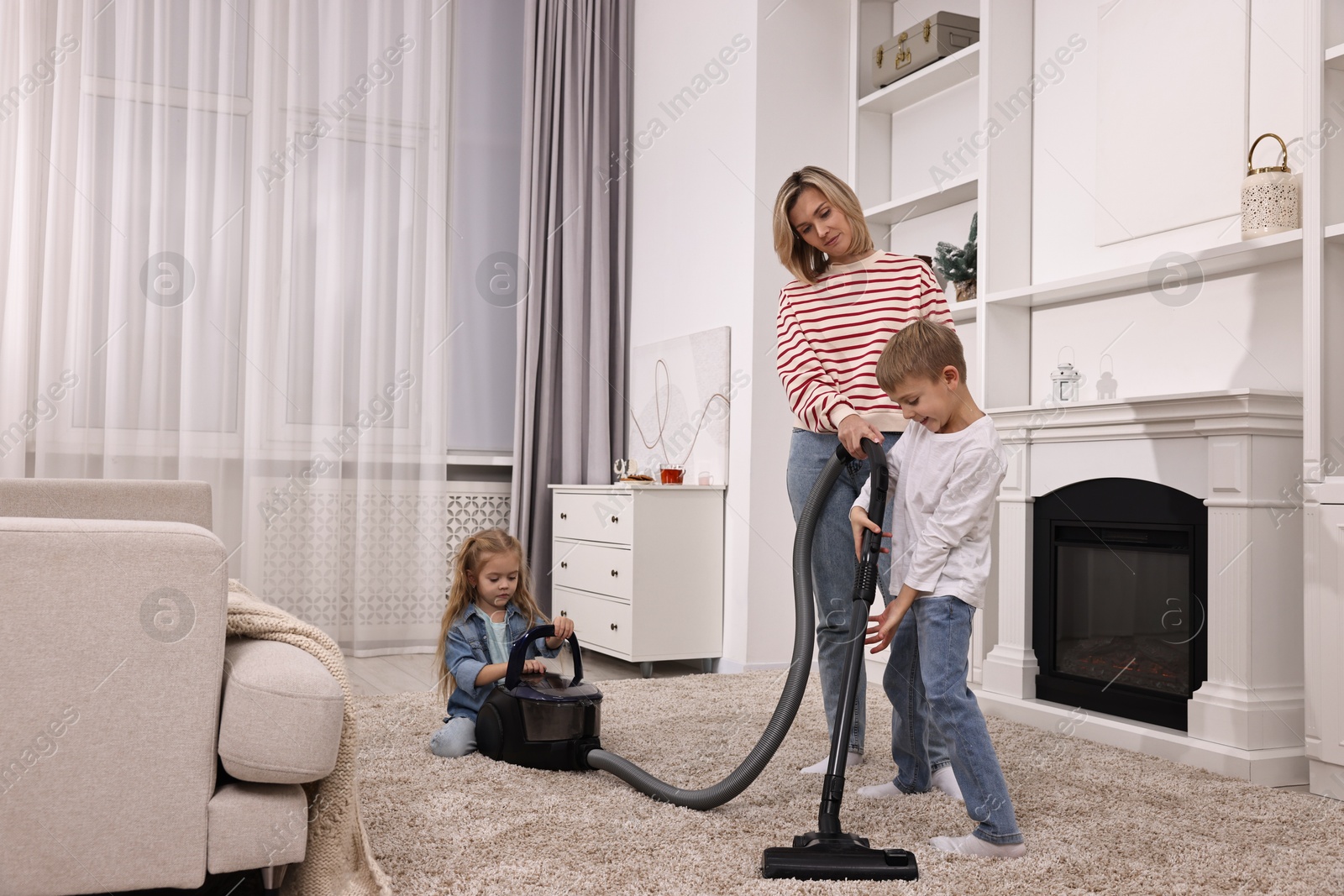 Photo of Housewife and her kids cleaning room together