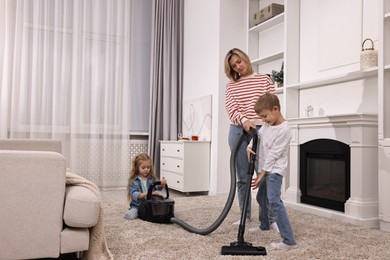 Housewife and her kids cleaning room together