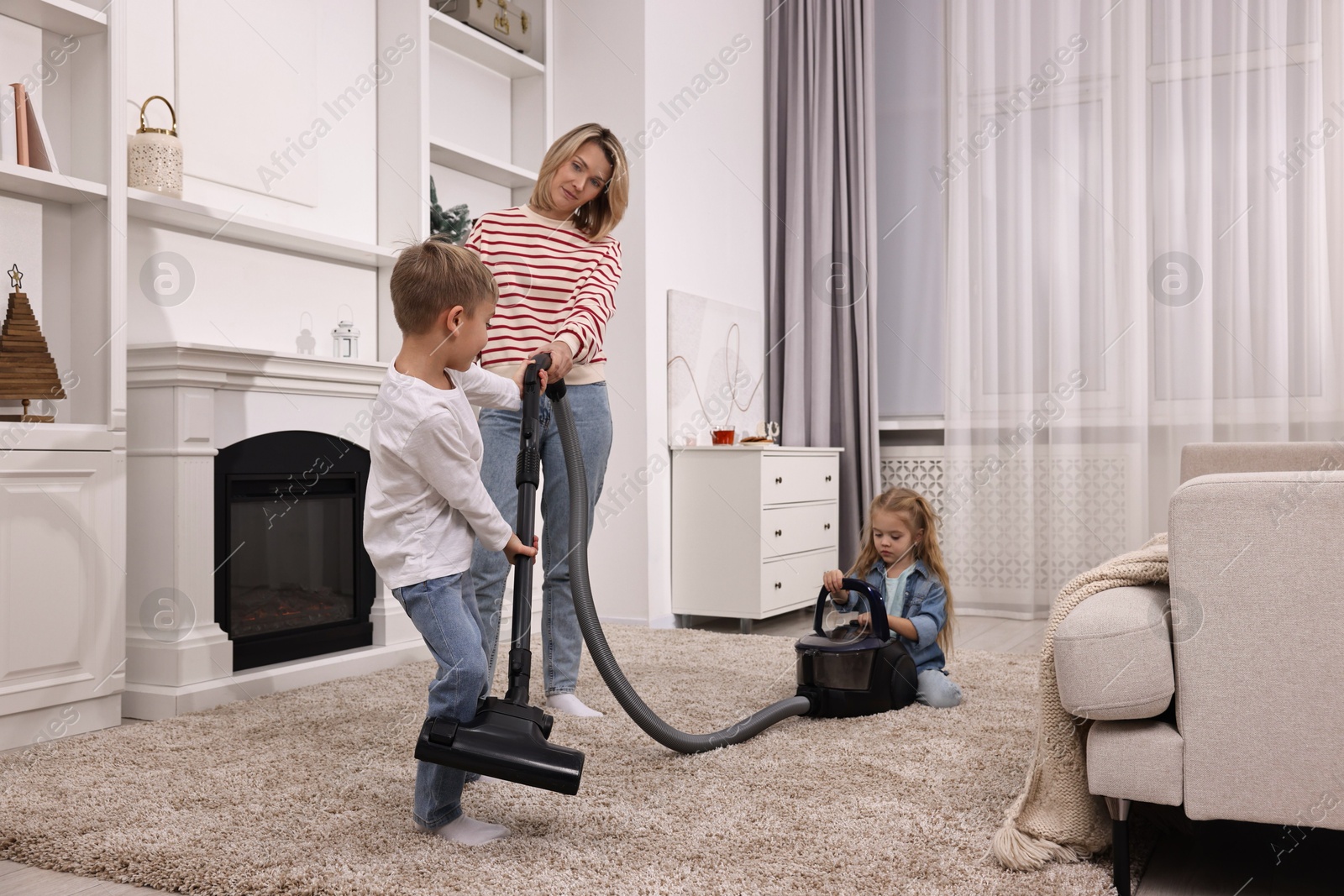 Photo of Housewife and her kids cleaning room together