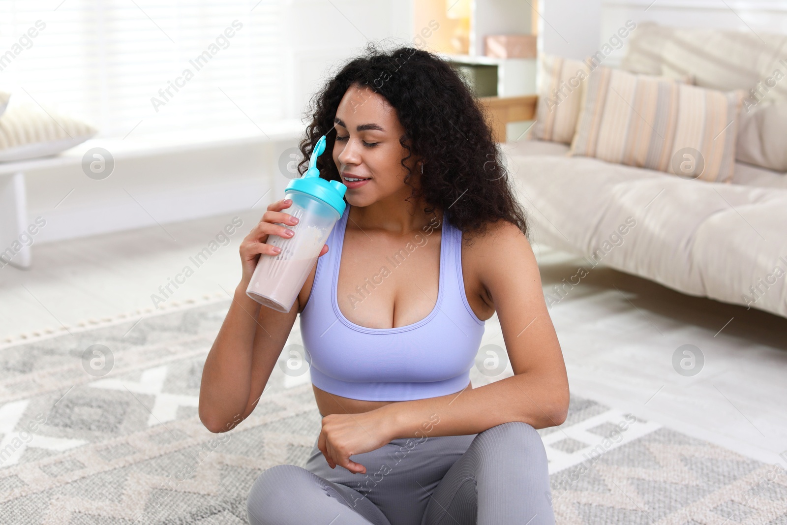 Photo of Beautiful woman drinking protein shake at home