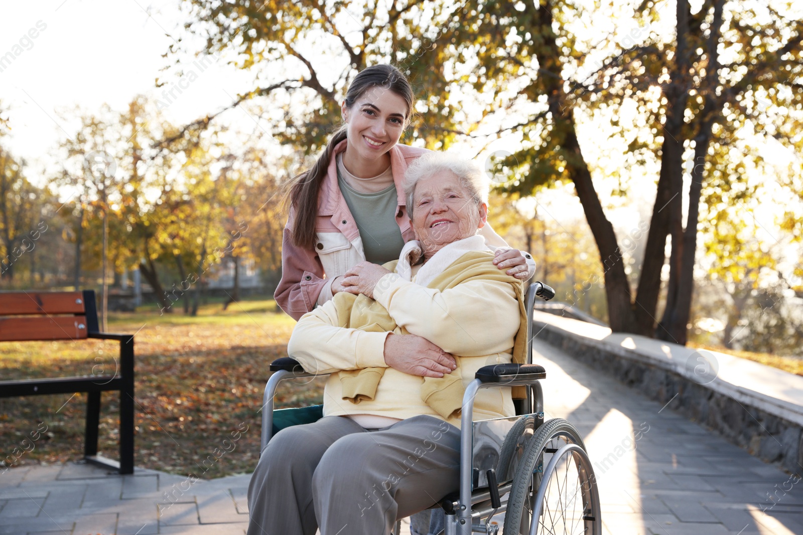 Photo of Caregiver with elderly woman in wheelchair at park